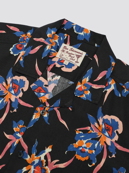 Black button-up shirt with signature botanical print featuring vibrant blue orange and pink floral pattern