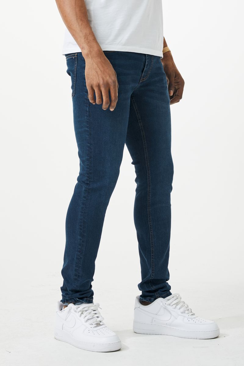 Dark blue skinny fit denim jeans with slim fit design, classic five pockets, and subtle thigh fading
