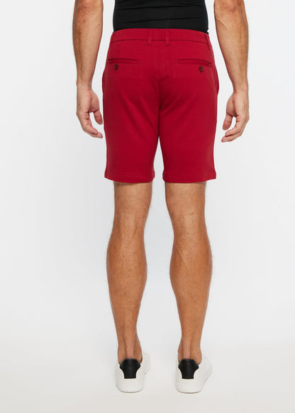 Red men’s solid stretch knit chino shorts with tailored fit and buttoned back pockets shown from the back side