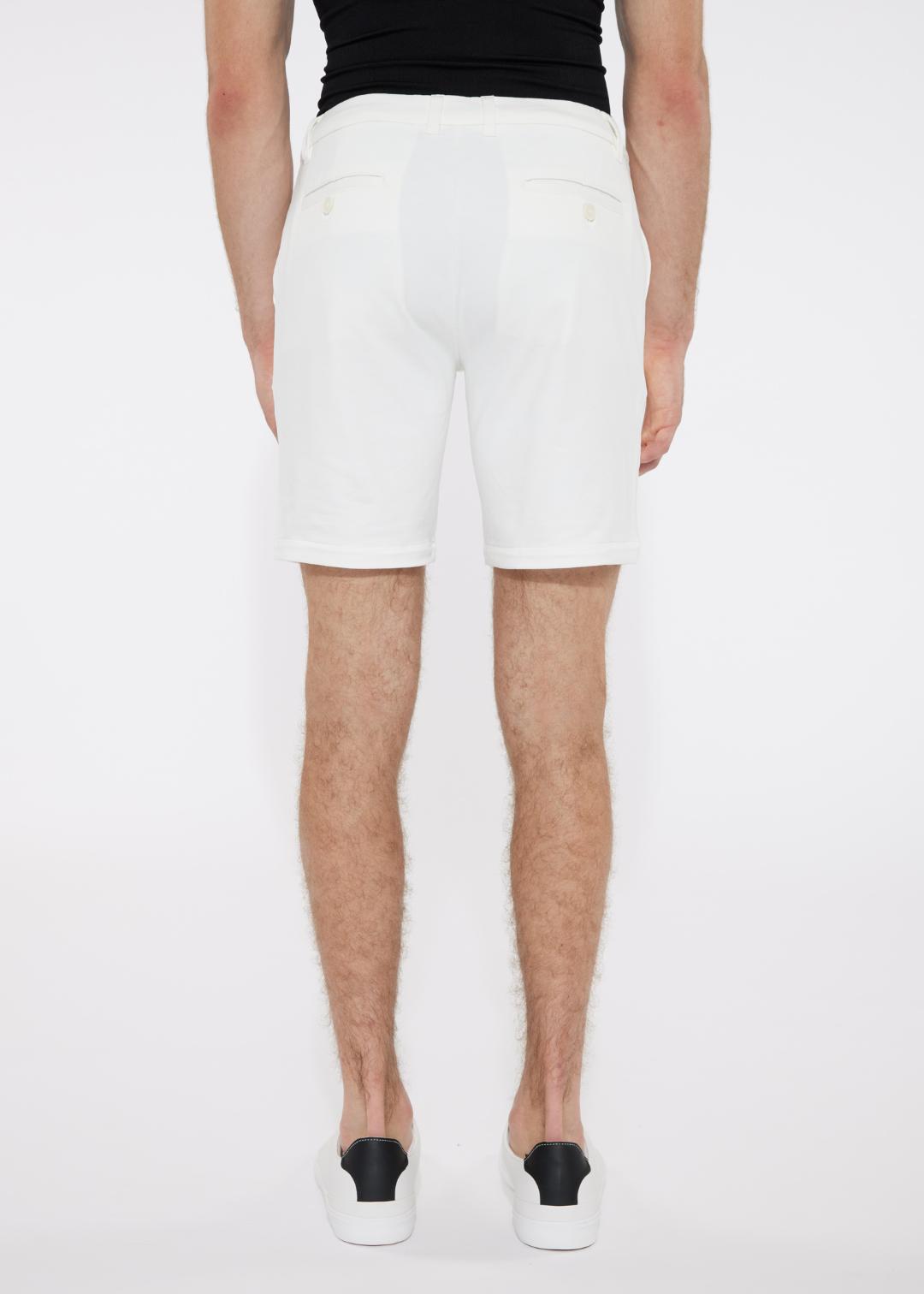 White solid stretch knit shorts with a tailored fit and subtle back pockets shown from the back side