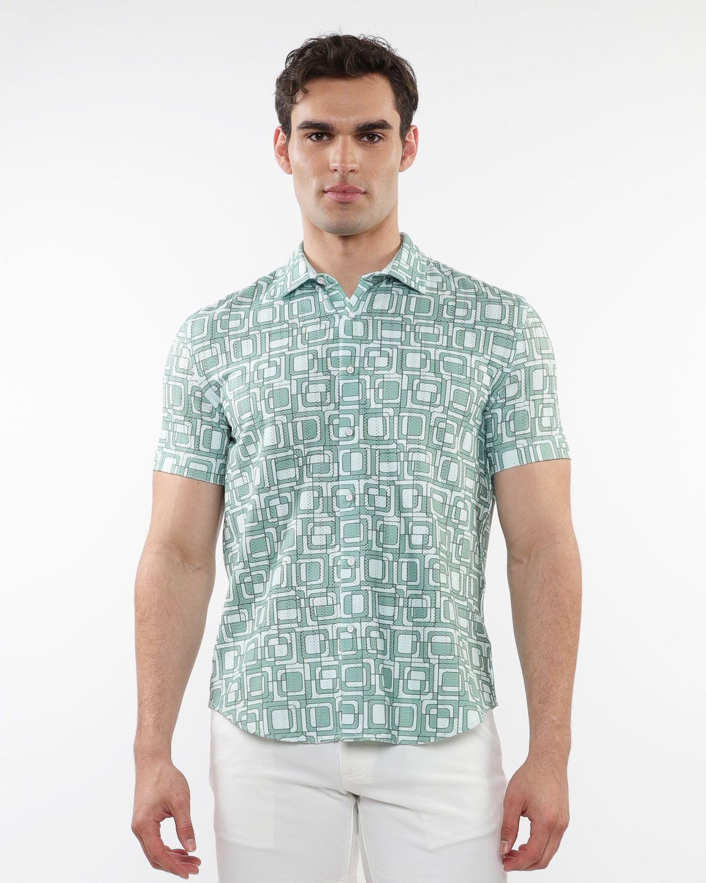 A man wearing a light green and white geometric patterned short-sleeve squares print open knit shirt