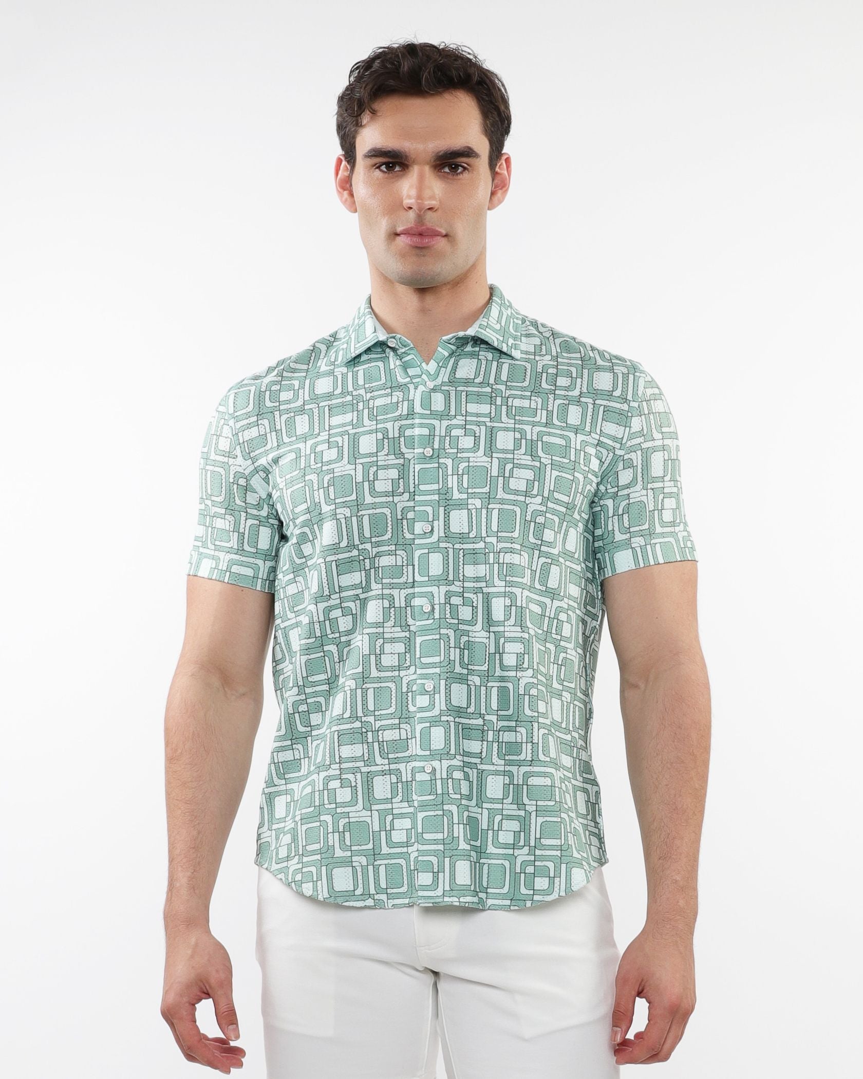 A man wearing a light green and white geometric patterned short-sleeve squares print open knit shirt