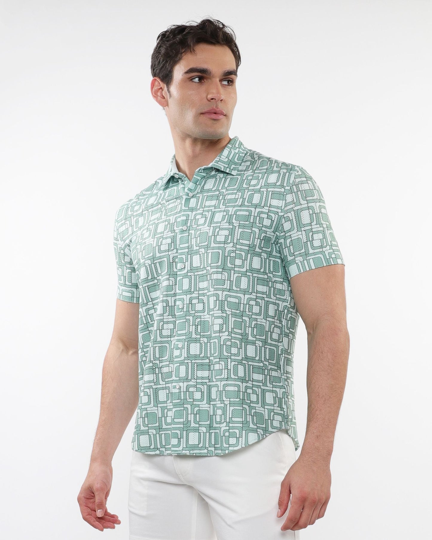 A man wearing a short-sleeved light green and white squares print open knit shirt with geometric patterns