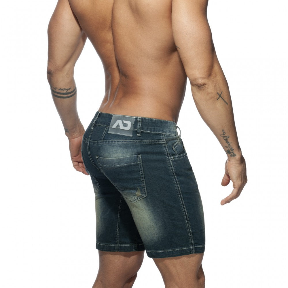Dark blue denim squat bermuda jeans shorts with faded wash and distressed details shown from the back side
