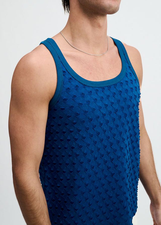 A person wears a petrol-colored stretch ripped knit tank top with a scoop neck against a white background.