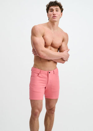 Crepe pink stretch knit shorts with belt loops, front pockets, and a button fly against a plain white background.