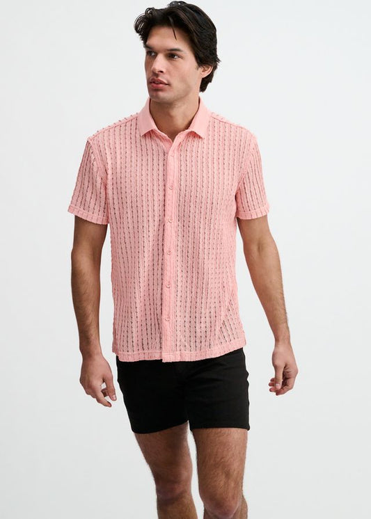 Pink open knit short-sleeve button-down shirt with a ribbed collar, worn with black shorts.