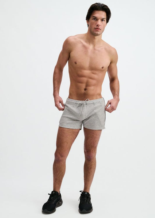 A shirtless man wearing short grey gym shorts with a drawstring.