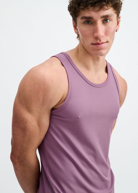 A person wearing a purple, ribbed active tank top with a scoop neckline, viewed from the chest up.