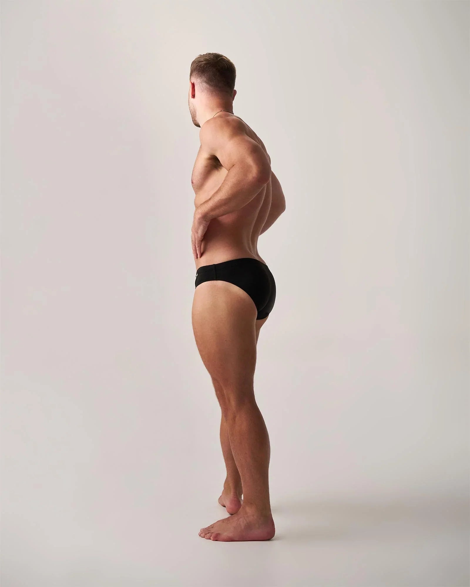 Black statement swim brief showing the back side made of quick-dry fabric ideal for swimming and beachwear