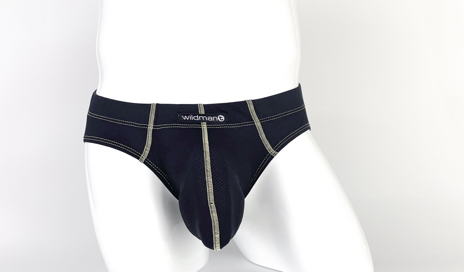 Black pouch brief with visible tan contrast stitching, center seam, and a "wildman" logo tag on a white mannequin.