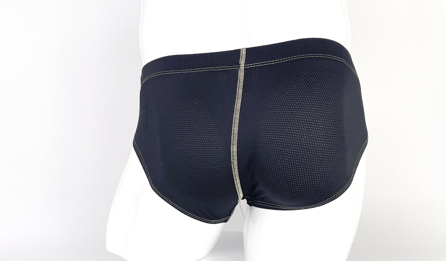 Black mesh pouch briefs on a mannequin with prominent, light-colored contrast stitching.