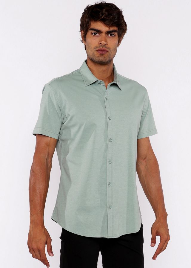 A man wearing a light green stretch knit short-sleeved button-up shirt with a classic collar and pressed fabric