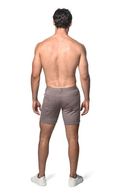 A pair of men’s taupe stretch knit shorts shown from the back with a relaxed fit and two pockets