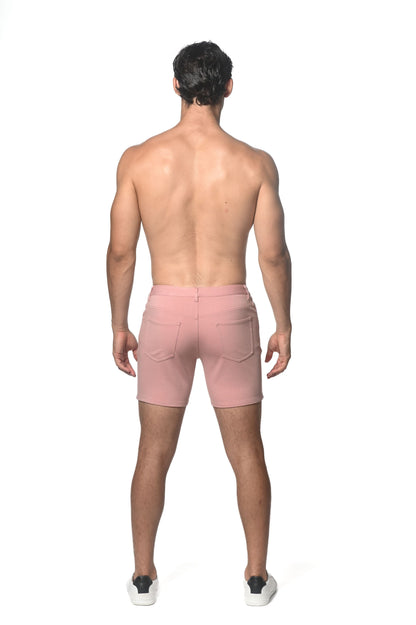 Pink stretch knit shorts shown from the back with two pockets and a zipper closure