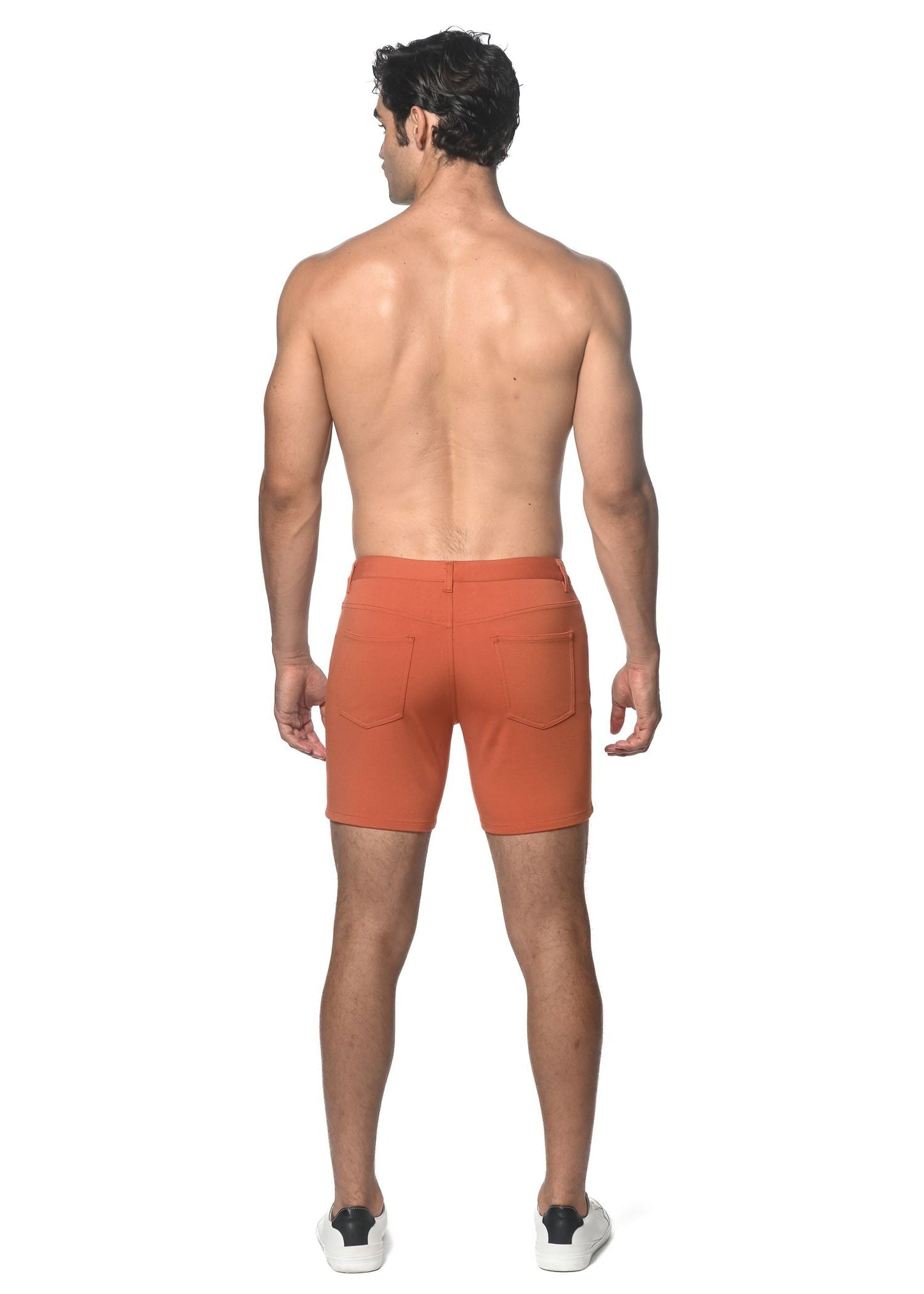 Orange stretch knit shorts back view with two pockets and a clean tailored fit in soft stretch fabric
