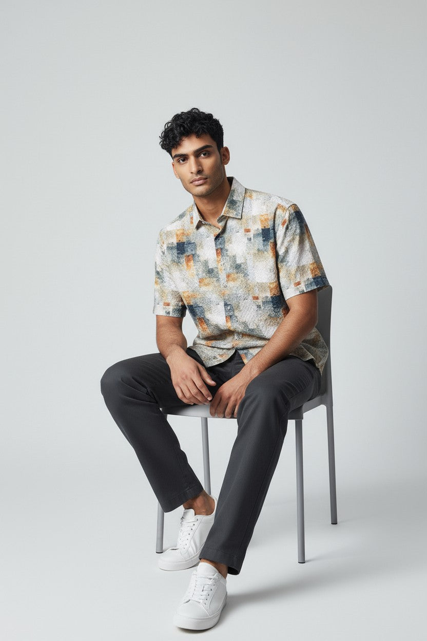 A man wearing a suslo crinkled fabric s s shirt with an abstract geometric pattern in beige gray and orange tones