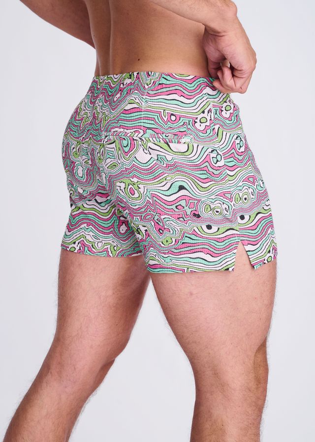 Swirls print seersucker swim shorts with mesh lining in vibrant pink green and white psychedelic wavy abstract pattern