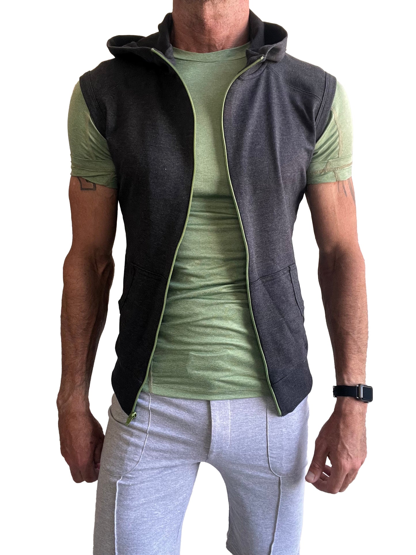 Dark gray sleeveless yoga hoodie with light green zipper and lining worn over olive green t shirt for workout wear