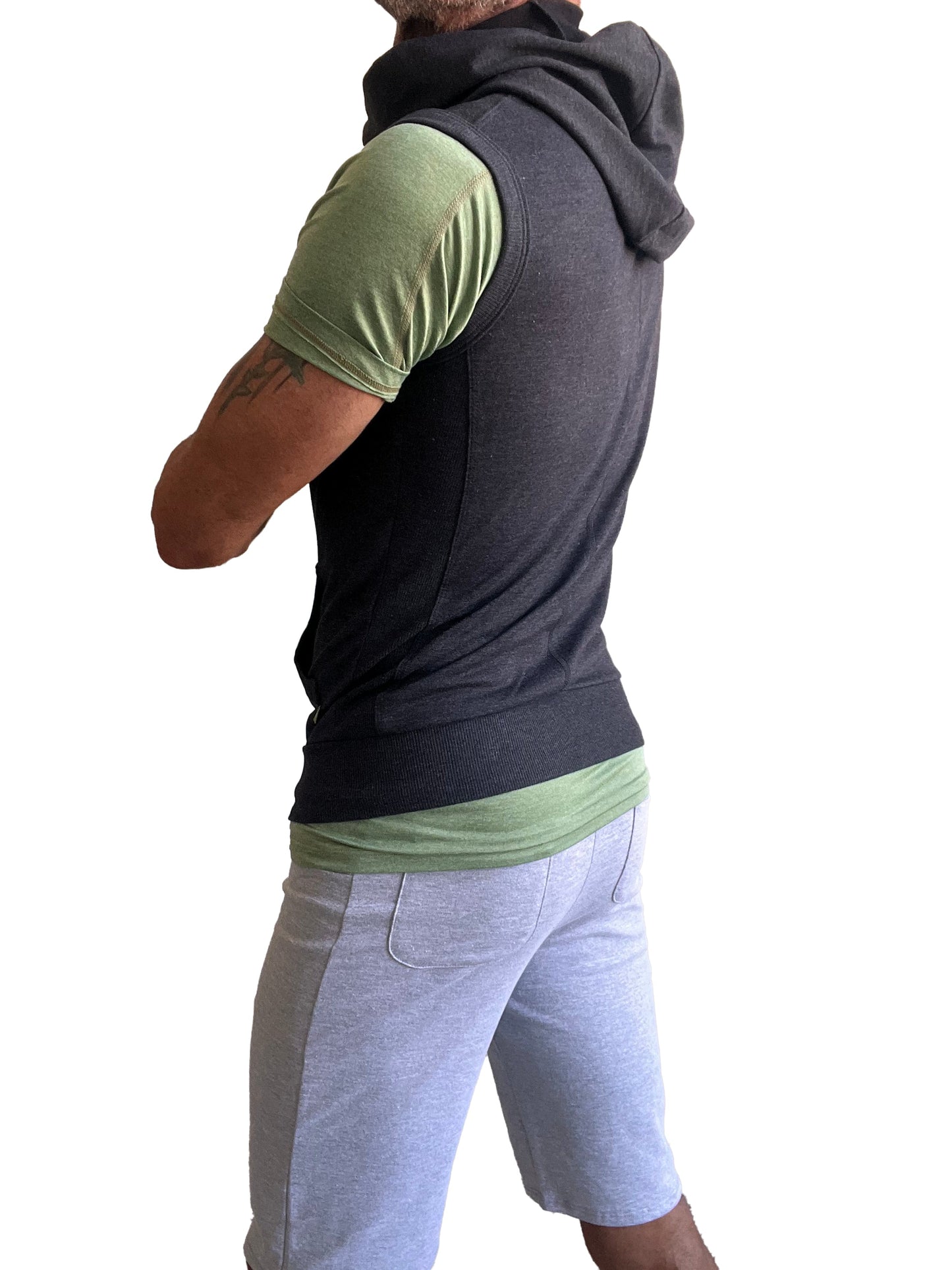Black hooded sleeveless vest worn over green short sleeved shirt shown from front in sleeveless yoga hoodie charcoal gray