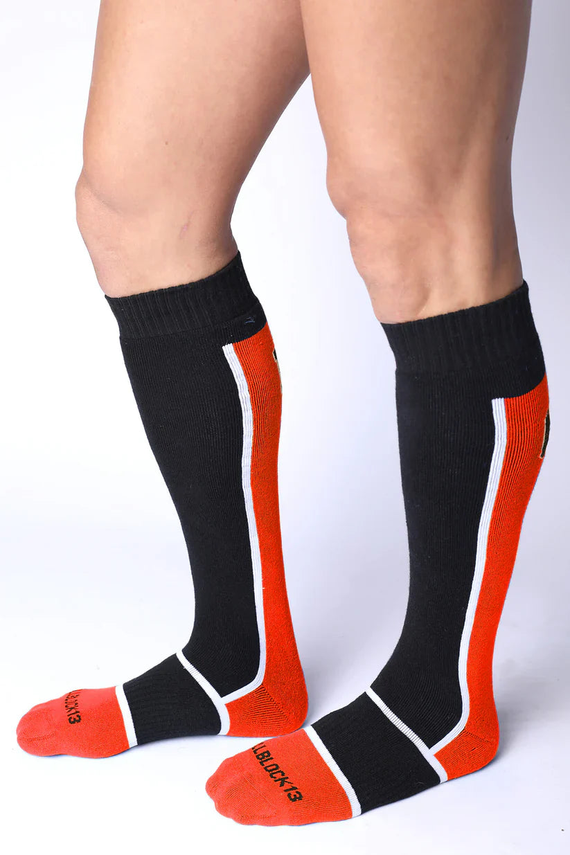 Take down knee high socks in black and orange with white trim ribbed texture and black & red logo on the foot
