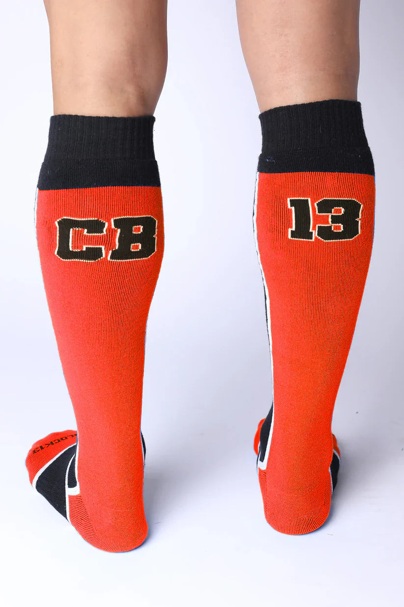 Take down knee high socks in bright orange with black ribbed cuffs toe accents and bold cb 13 lettering outlined in white
