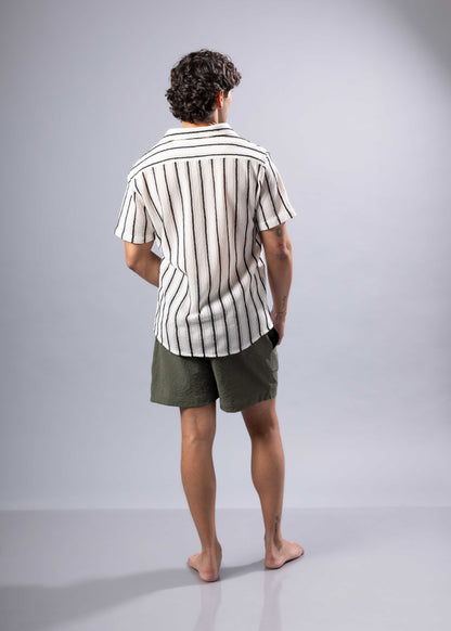 A man wears a texture knit short-sleeved shirt with vertical black and white stripes