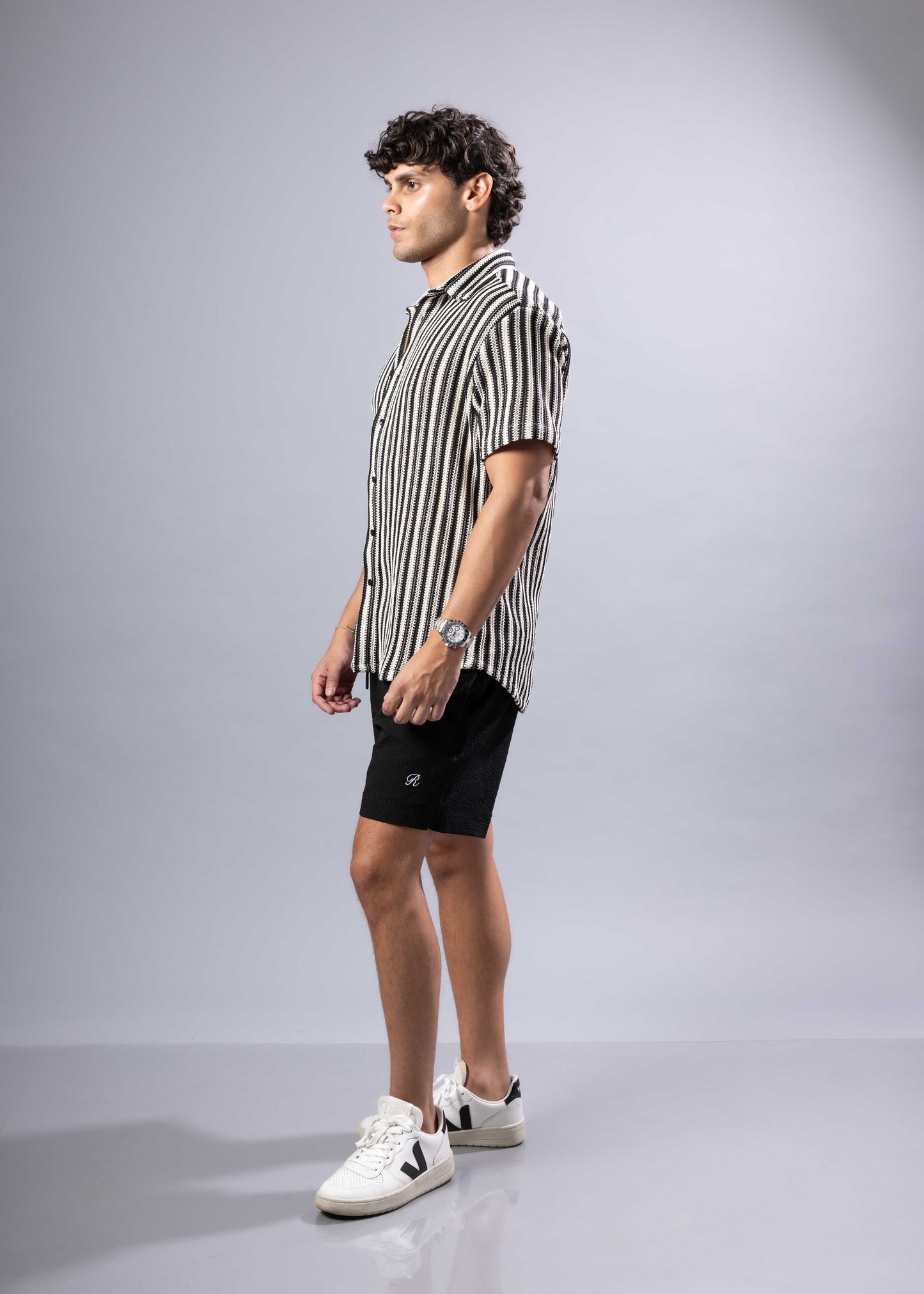 A man wearing a black and white vertically striped texture knit short-sleeved shirt product s s shirt