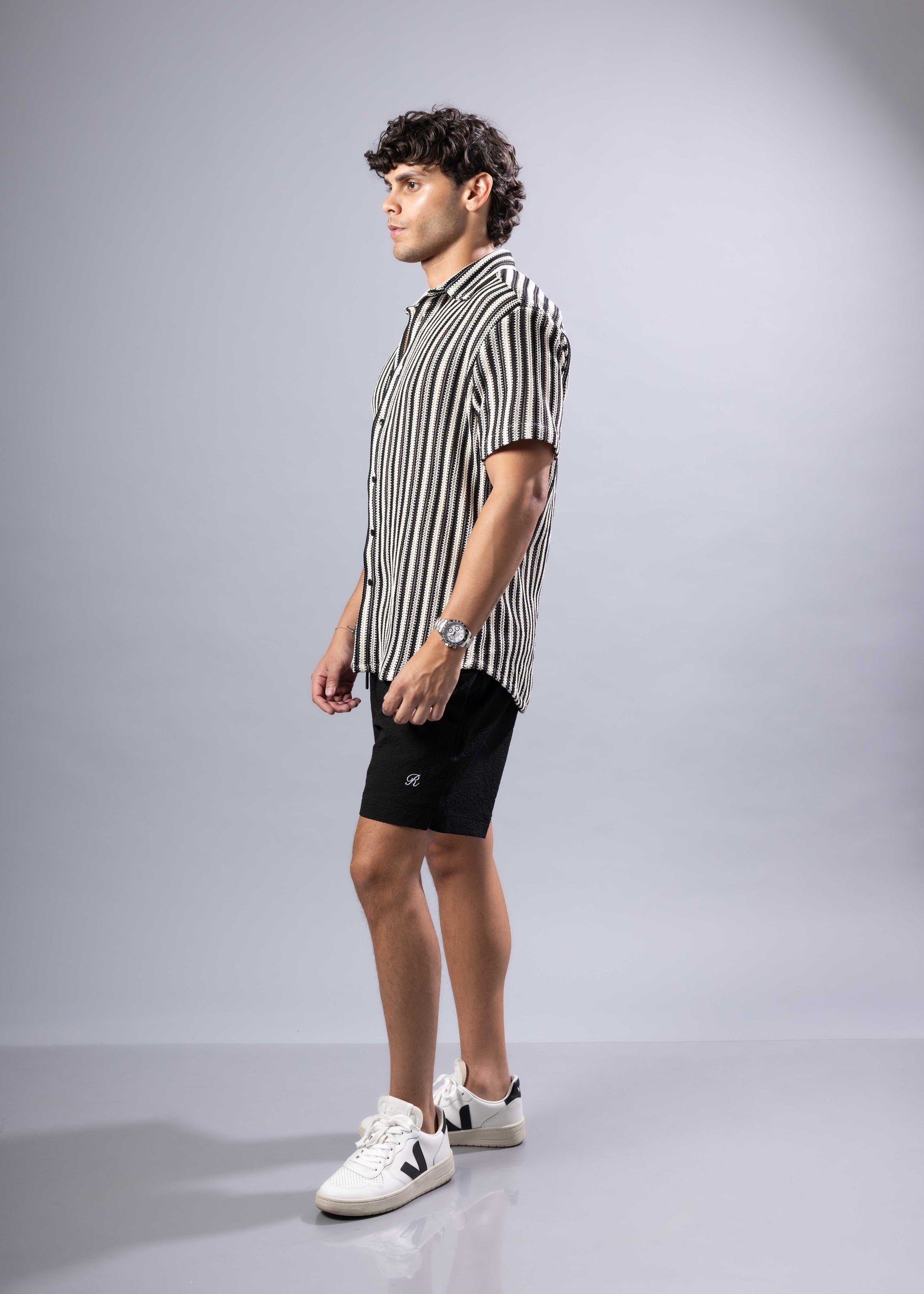 A man wearing a black and white vertically striped texture knit short-sleeved shirt product s s shirt