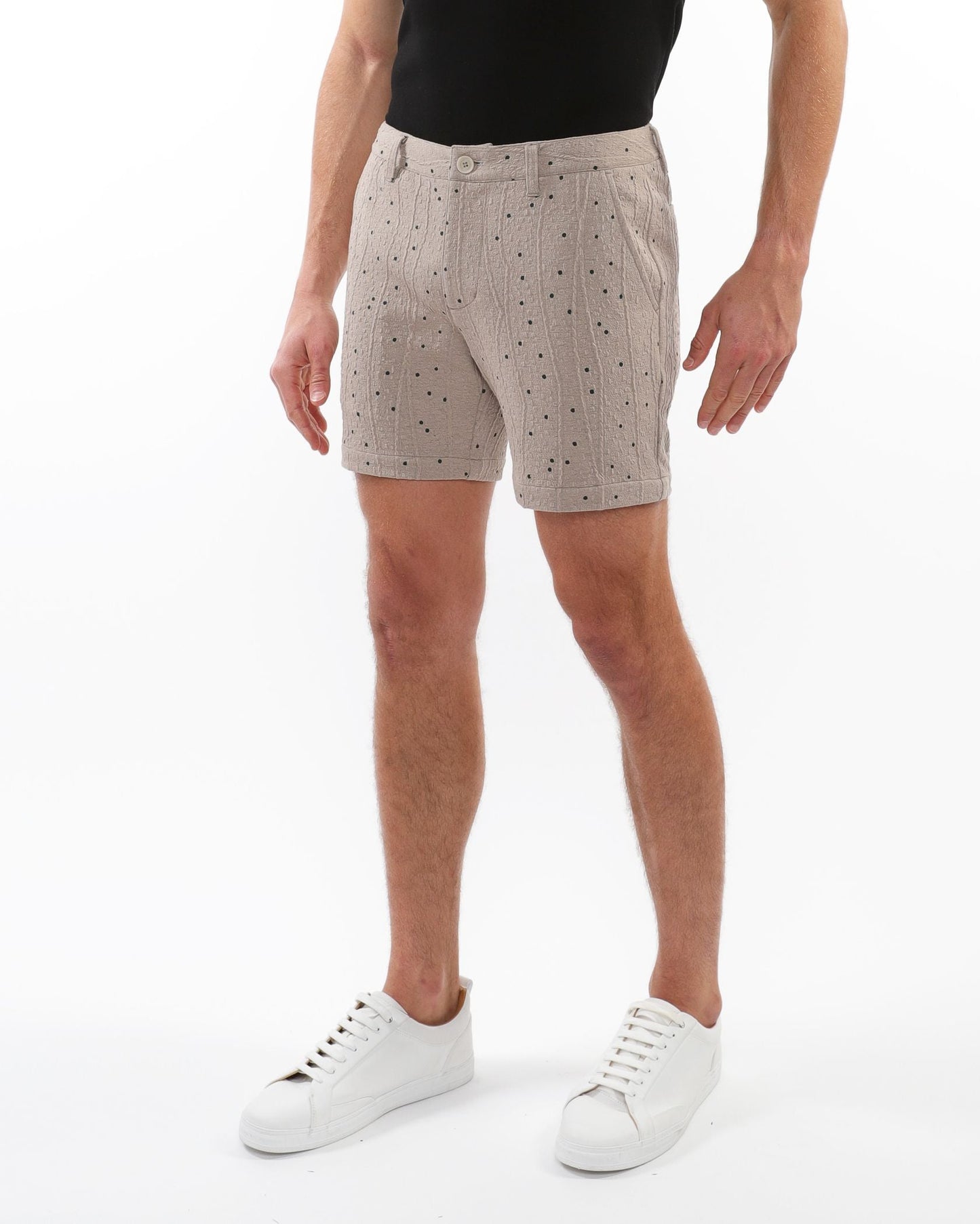 Beige textured jacquard stretch chino shorts with a subtle black polka dot pattern and woven fabric detail