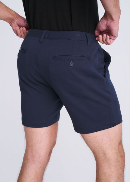 Dark navy blue textured stretch knit chino shorts with tailored fit and subtle button detail on back pocket showing back side