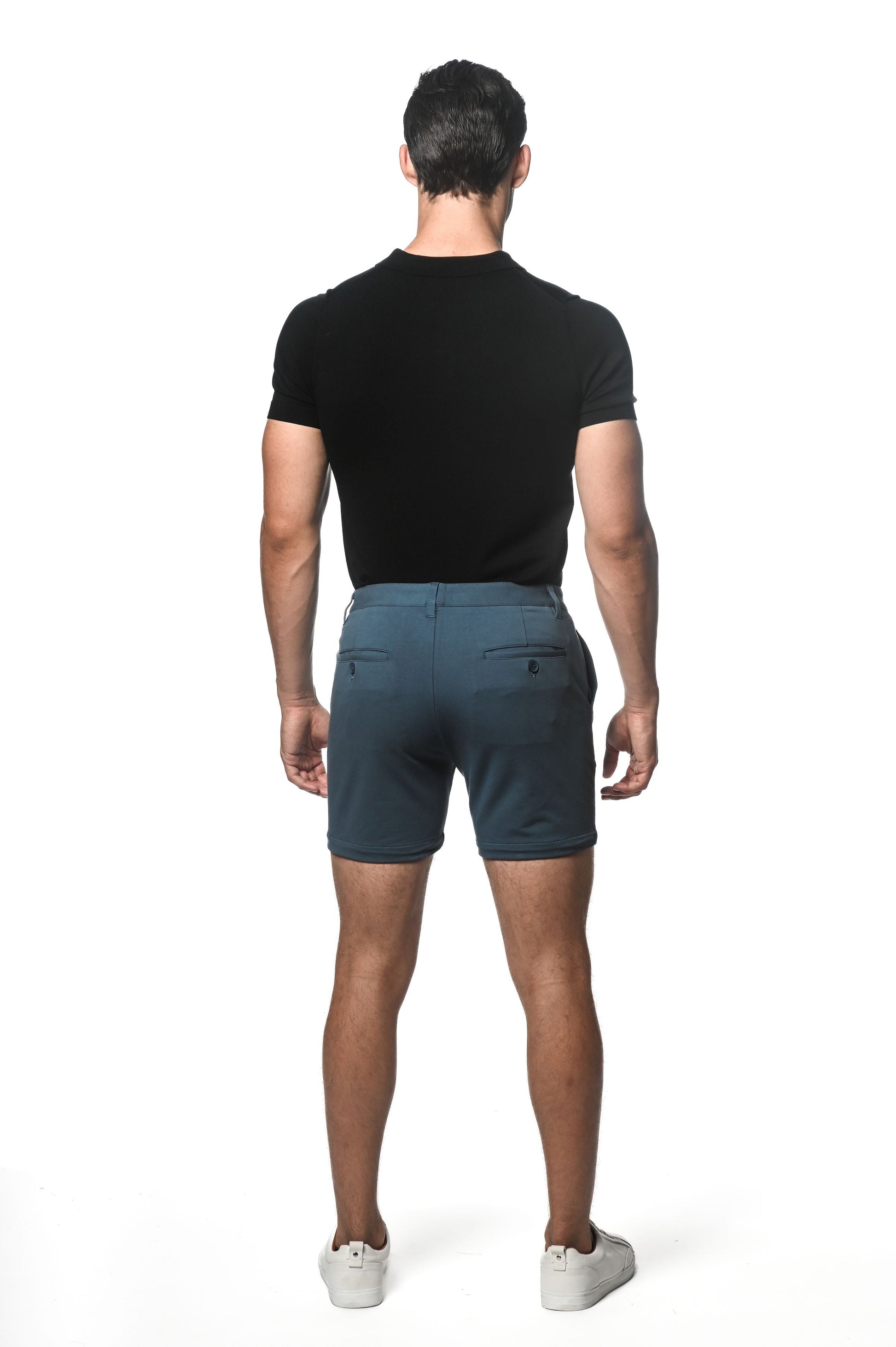 Dark teal textured stretch knit chino shorts with subtle gradient fade and two back pockets shown from the back side