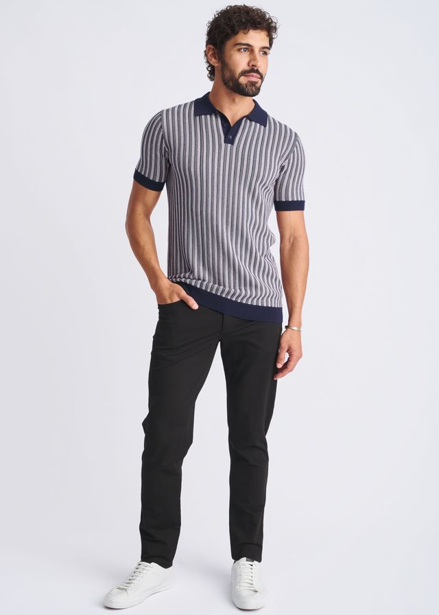 A man wearing a textured stripes silk tencel polo in navy and gray with dark blue collar cuffs and hem