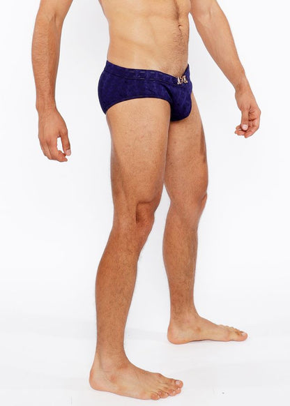 Navy blue textured swim brief with front buckle and metallic logo on waistband designed for swimming and beachwear