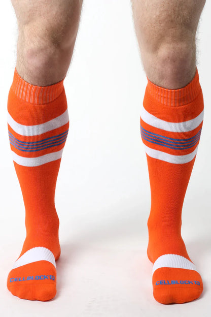 Tight end knee high socks in bright orange with white and purple stripes featuring ribbed cuff and toe design