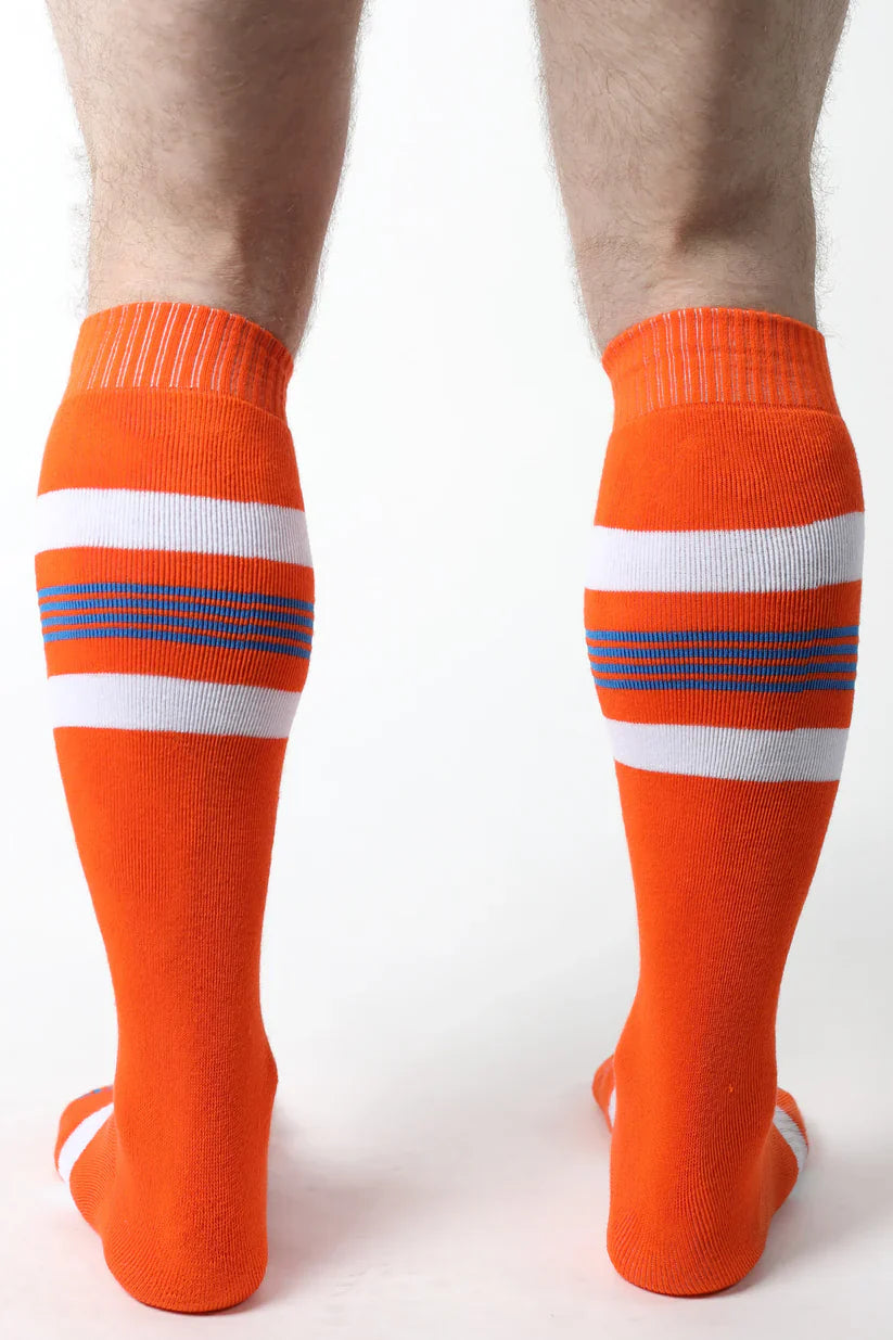 Tight end knee high athletic socks in bright orange with white and navy blue horizontal stripes for sports use