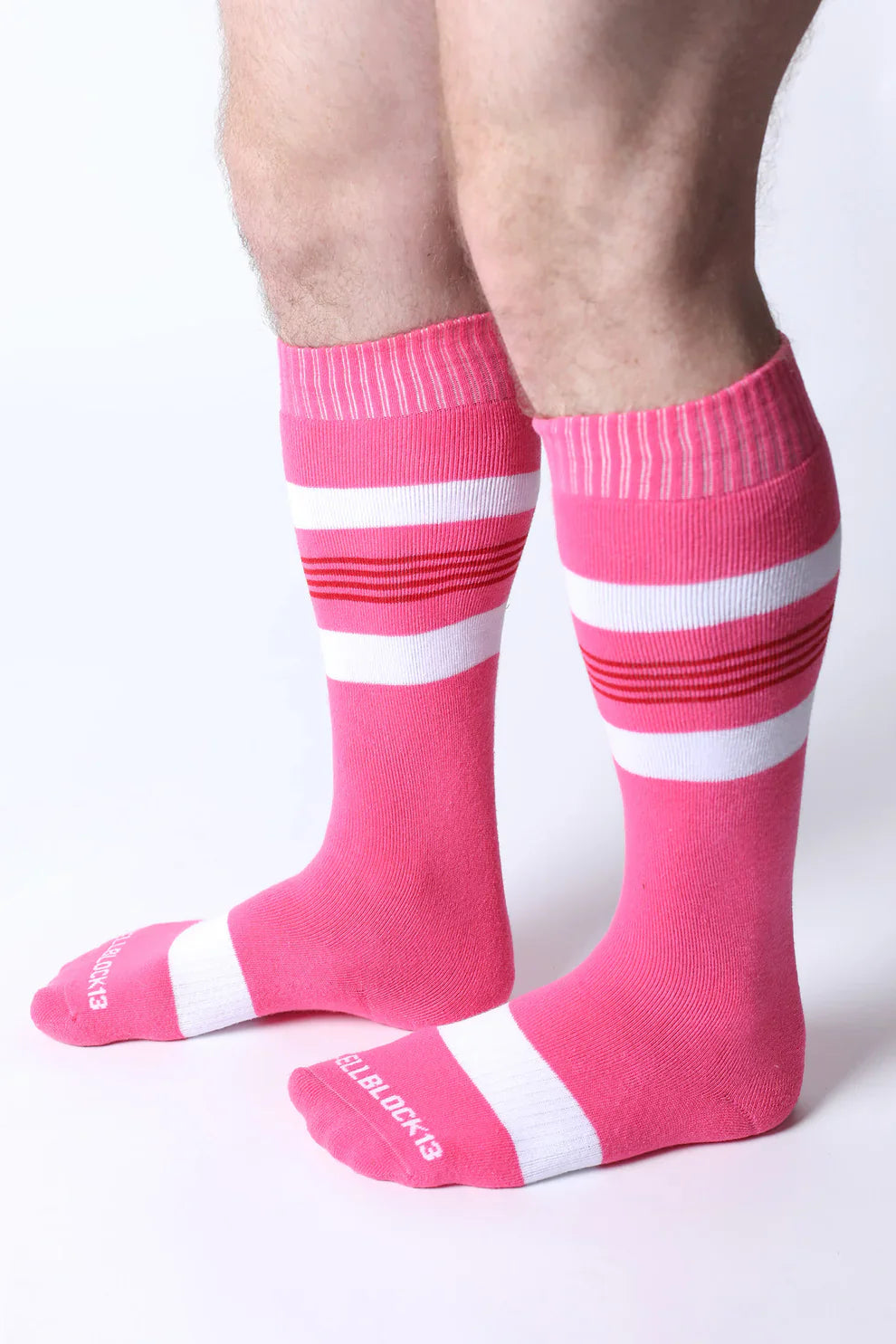 Bright pink tight end knee high socks with bold white and red stripes featuring ribbed cuff and toe design