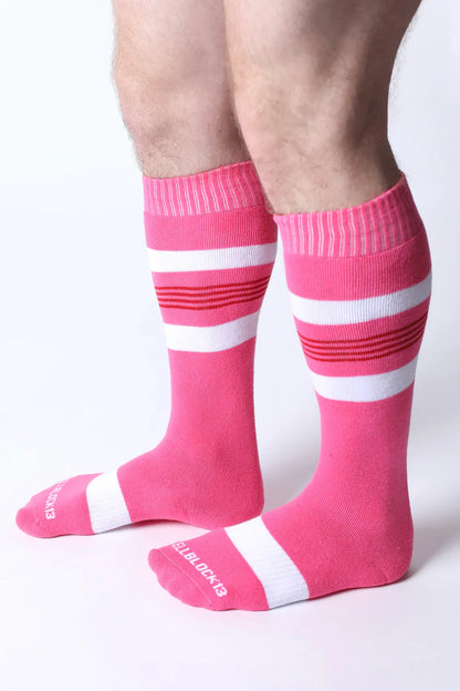 Bright pink tight end knee high socks with bold white and red stripes featuring ribbed cuff and toe design