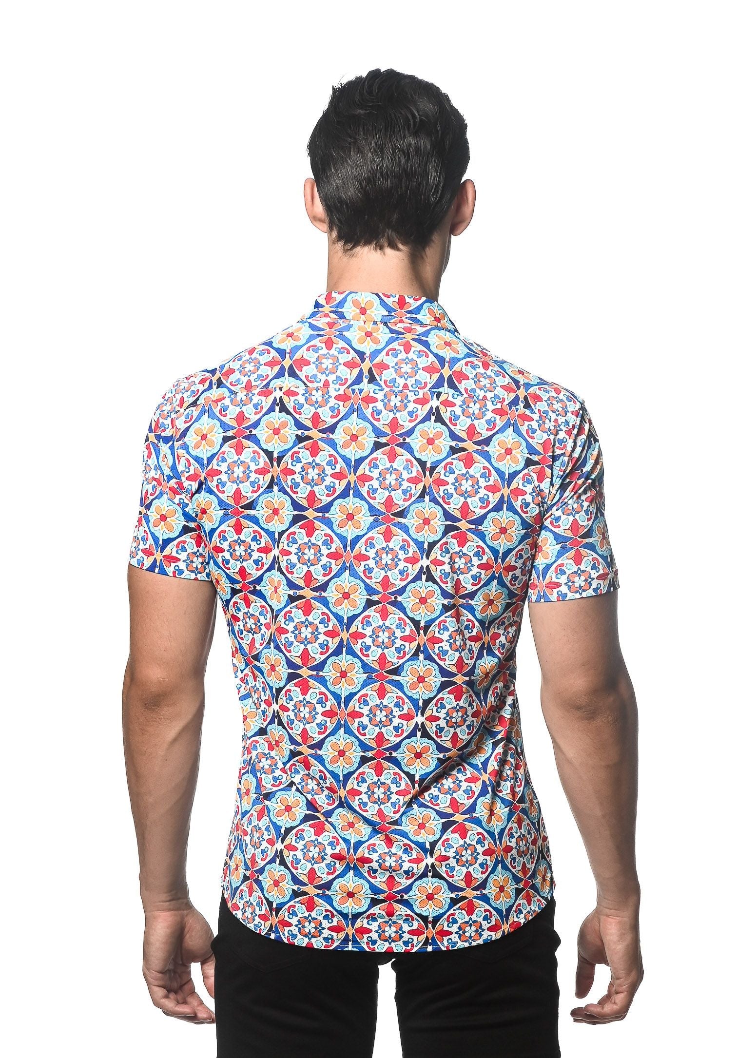 A man wearing a tile printed performance short-sleeved shirt with contrast placket in red blue and cream tones