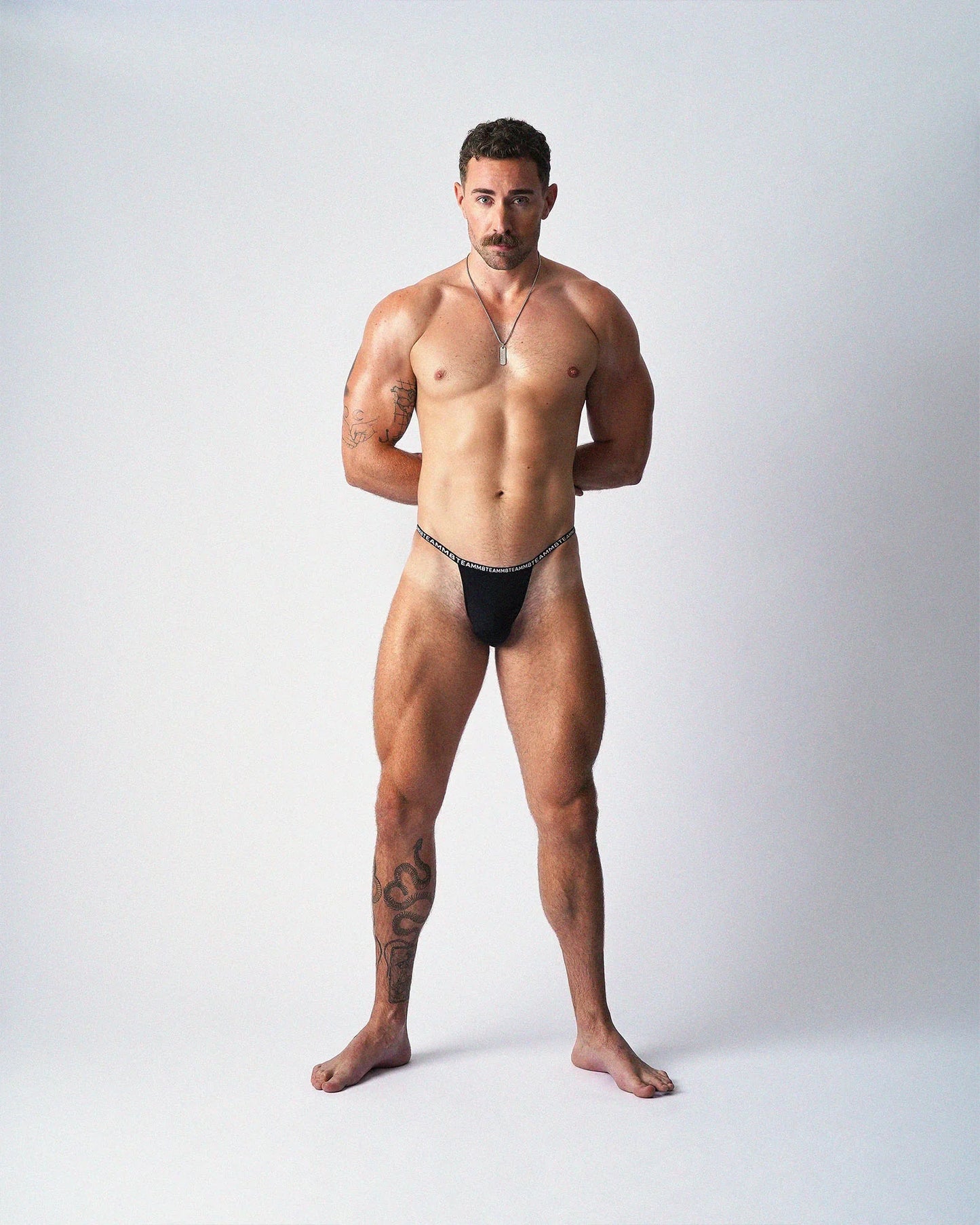 Minimalist black thong with a thin elastic waistband and text graphic.