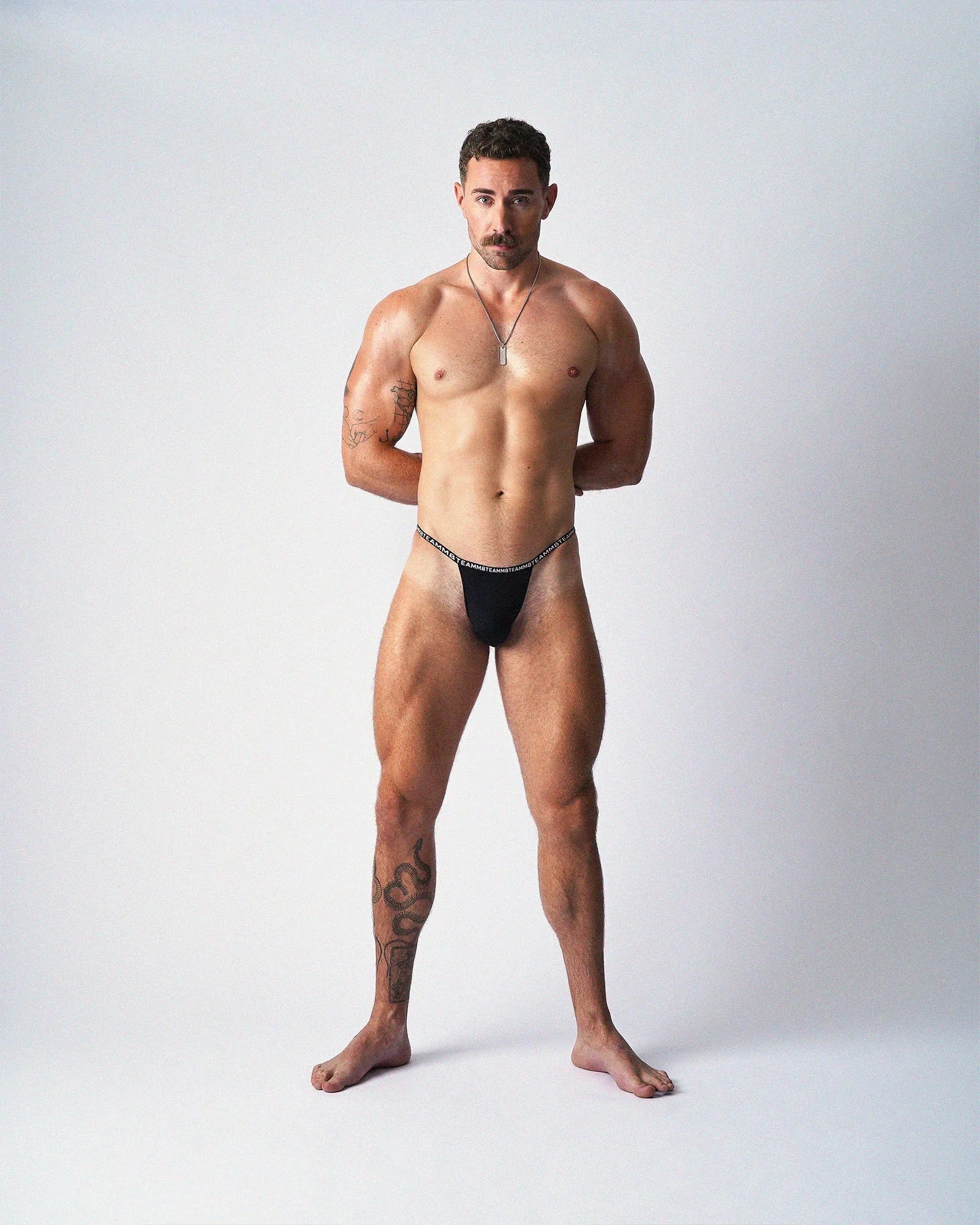 Minimalist black thong with a thin elastic waistband and text graphic.