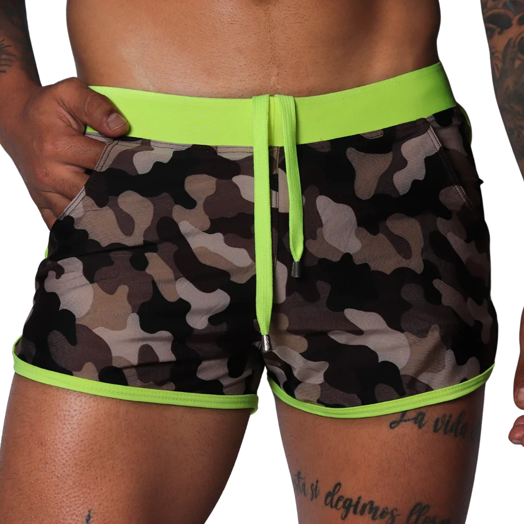 Short camouflage swim trunks with neon yellow elastic waistband, matching drawstring, and neon yellow piped trim.