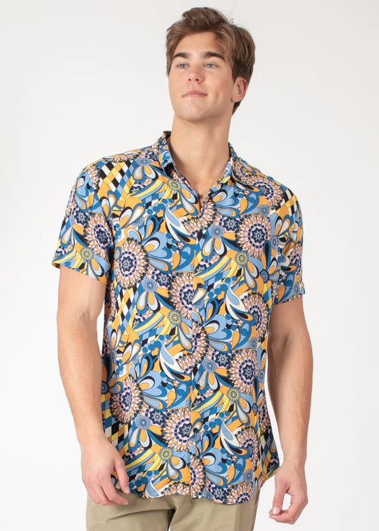 A vibrant blue and yellow floral-patterned tropical abstract short-sleeve button-up shirt with a classic collar