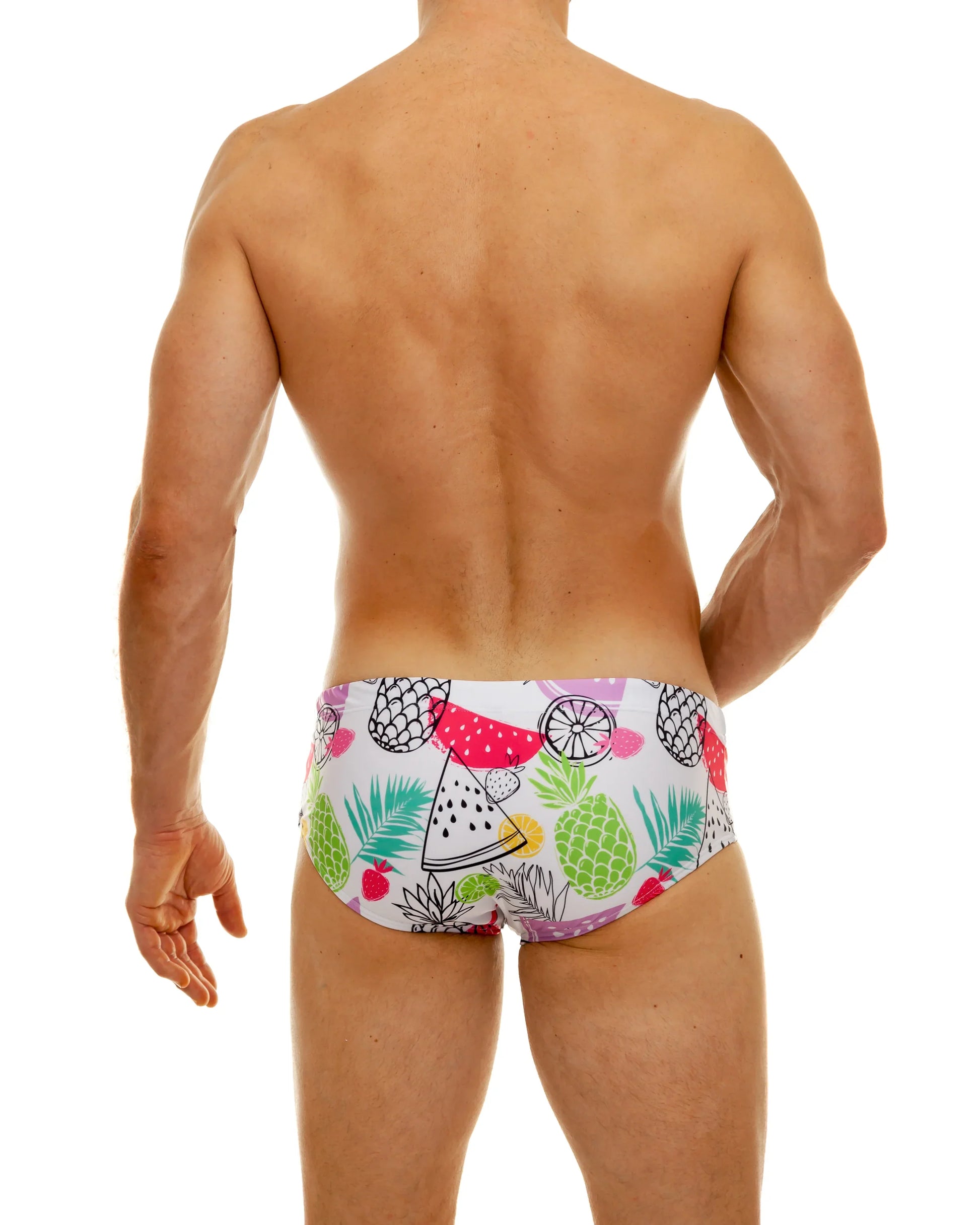 White tropical fruit swim brief with vibrant watermelon pineapple and leaf pattern in pink green yellow and black