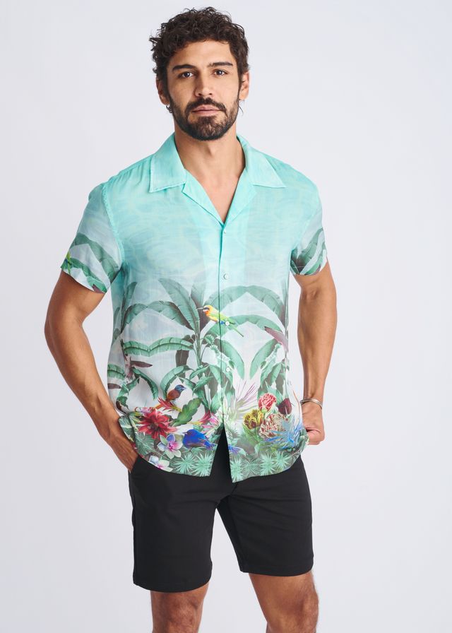 A men’s short-sleeved button-up modal shirt in vibrant turquoise with tropical green leaves and colorful birds print