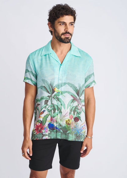 A vibrant turquoise tropics border print short-sleeved modal shirt with tropical birds and lush foliage design