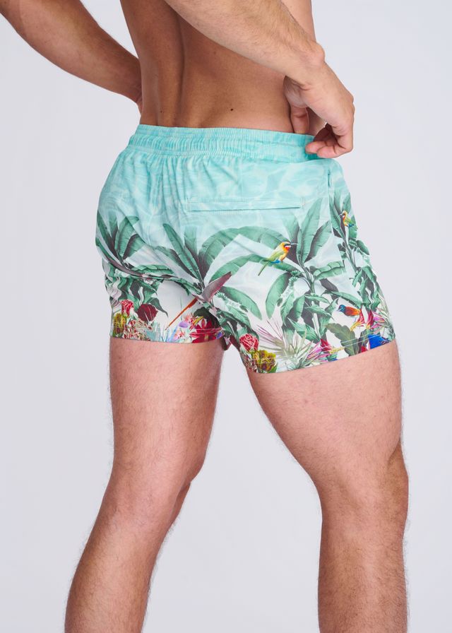 Light blue tropics print swim shorts with mesh lining featuring vibrant green leaves colorful birds and red flowers