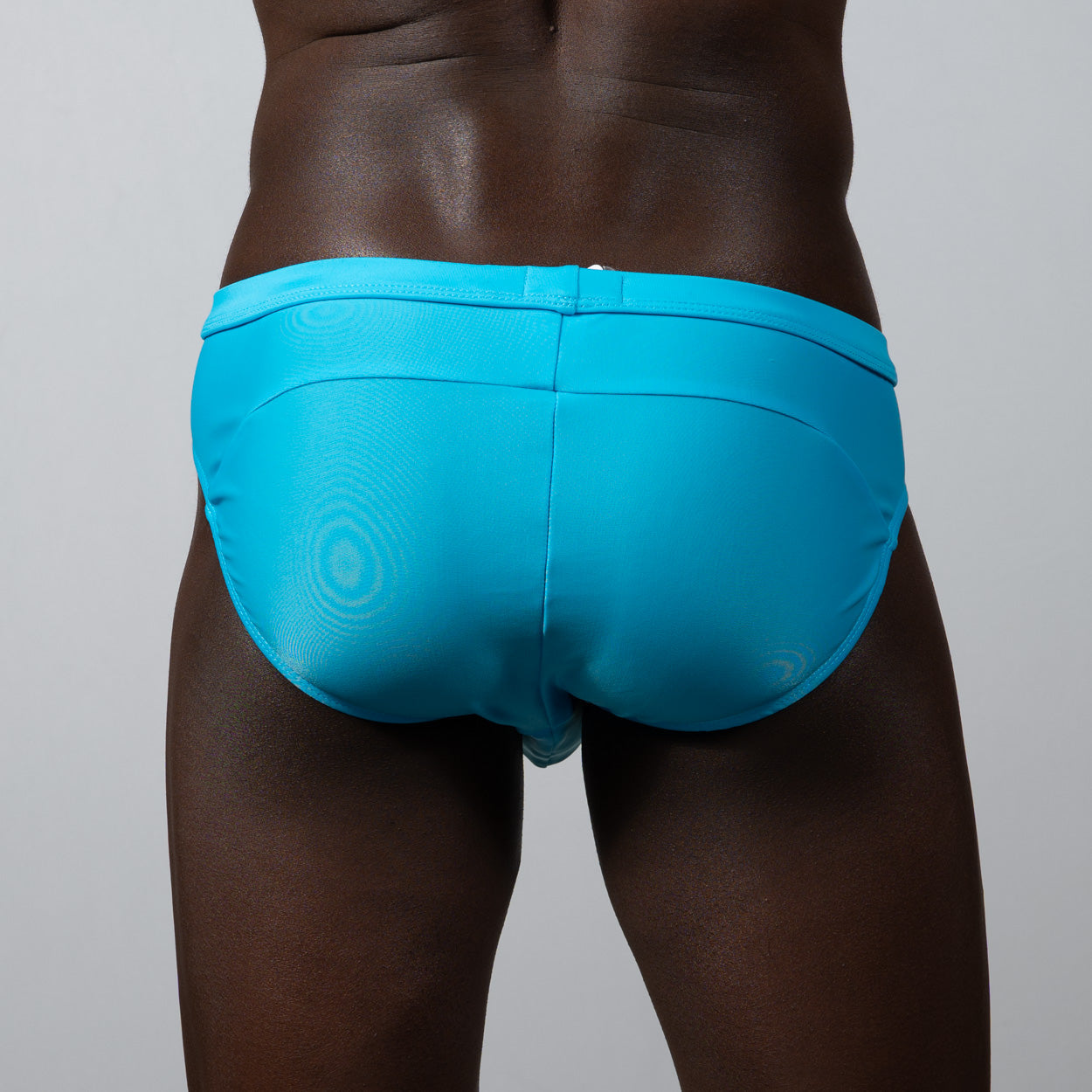 Tulio bikini brief solid bright turquoise swim trunks with subtle circular pattern and sleek form-fitting design