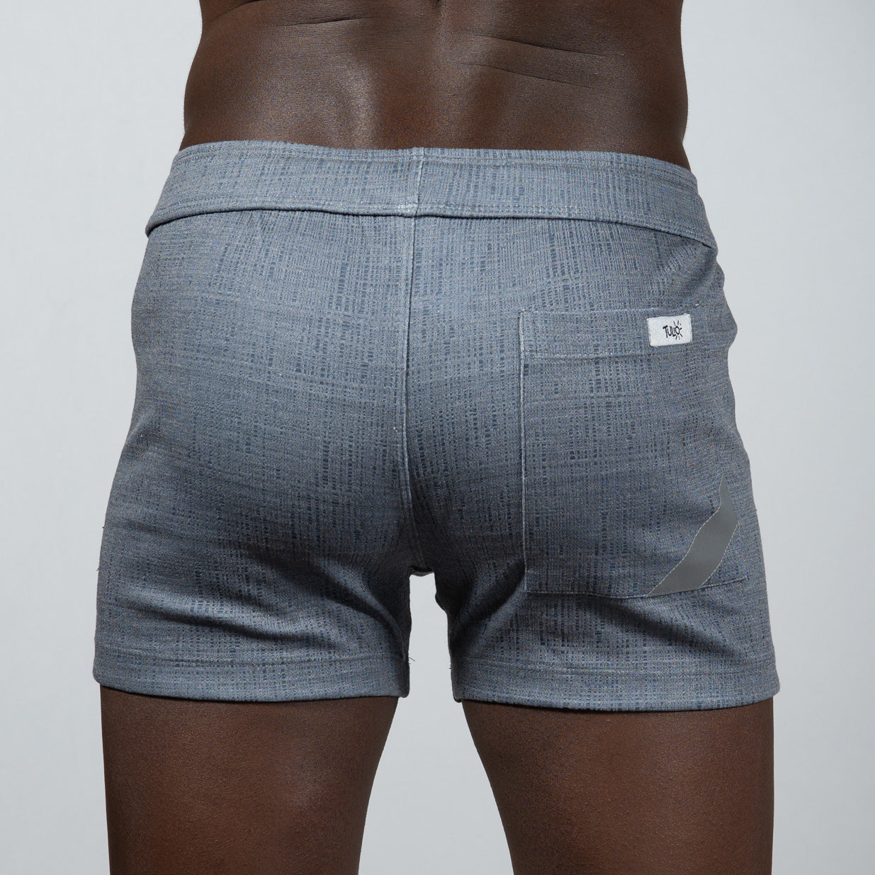 Back side of gray tulio linen texture shorts featuring a subtle woven pattern and a small white brand tag on the pocket