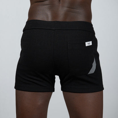 Black tulio linen texture shorts with ribbed waistband and silver reflective side stripe for athletic use
